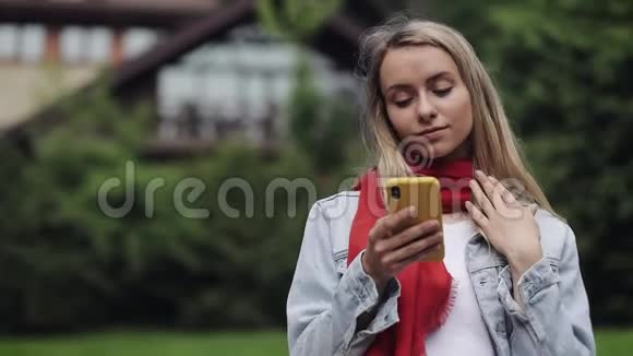 使用智能手机查看手机庆祝好消息的年轻美女戴着红领巾的画像视频的预览图