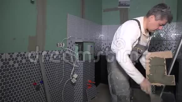 工人用刀在瓷砖背面涂胶视频的预览图