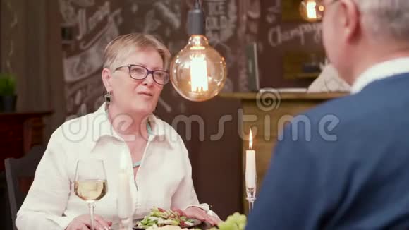 一个年纪相当大的女人为了一杯酒和她的伴侣聊天视频的预览图