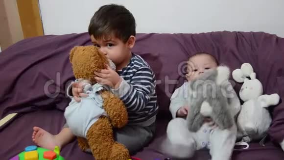 可爱的4个月大的男孩穿着紫色的床上用品和兔子玩具视频的预览图