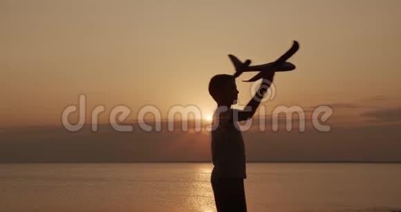 快乐的孩子在日落背景下带着玩具飞机跑步童年的梦想视频的预览图
