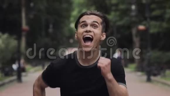疯狂的年轻帅哥在公园背景下奔跑视频的预览图