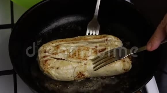 在一个加了黄油的加热煎锅里鸡角卷被炸了一个男人拿着叉子你可以看到油是如何沸腾的视频的预览图