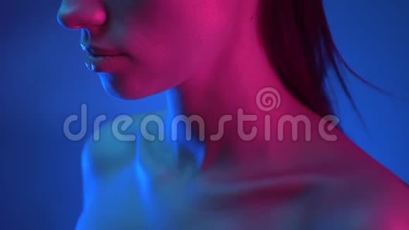 站在蓝色和粉红色霓虹灯中一动不动发光模型的特写镜头视频的预览图