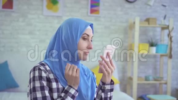 美丽的年轻穆斯林妇女不高兴地照镜子视频的预览图