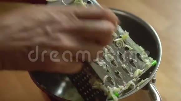 女人用手在金属烤架上摩擦西葫芦视频的预览图