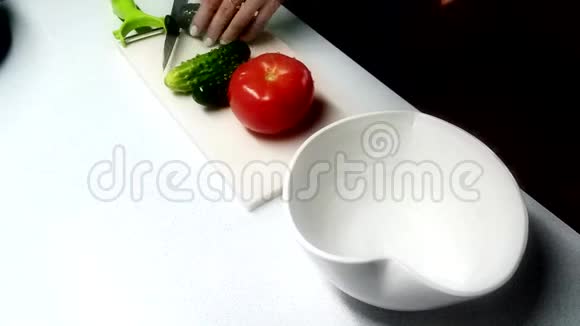 为女性做健康沙拉在砧板上切黄瓜西红柿橄榄和欧芹视频的预览图