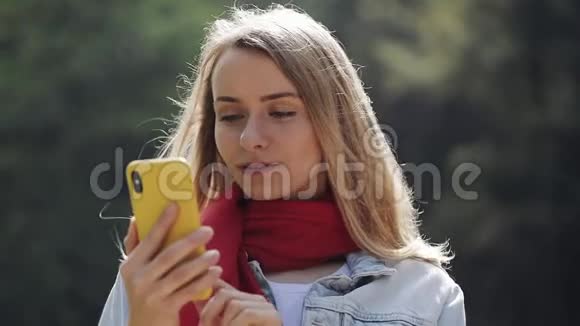 使用智能手机查看手机庆祝好消息的年轻美女戴着红领巾的画像视频的预览图