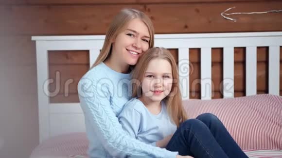 中镜头的幸福母亲拥抱她的小女儿看镜头的肖像视频的预览图