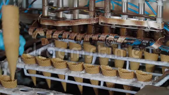 机器人机器自动将巧克力倒入晶片杯中用于制冰的输送机自动生产线视频的预览图
