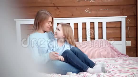 年轻有爱心的母亲拥抱着她的小女儿亲吻着她的女儿感觉最好视频的预览图