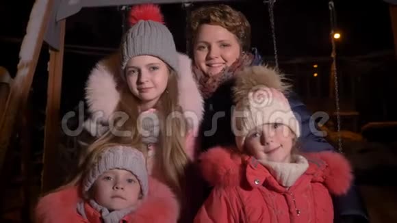 白种人的母亲和三个女儿在晚上的城市里吃着雪高兴地看着镜头的家庭画像视频的预览图