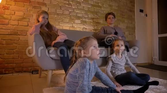 白种人小女孩在舒适的家里聚精会神地看电影互相交谈的肖像视频的预览图