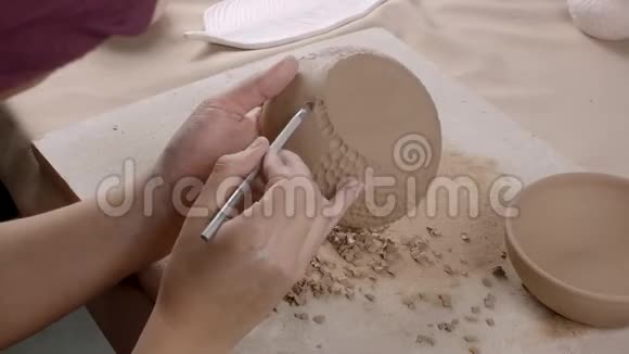 陶瓷盘子上的陶工装饰品女人陶瓷把纹理放在盘子上特写镜头视频的预览图