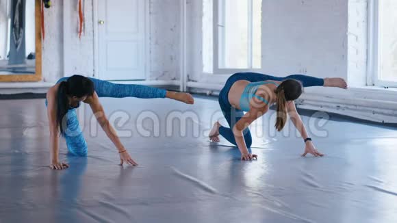 两名运动女性在健身馆做运动女运动员通过做普拉提锻炼来改善肌肉视频的预览图