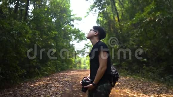 一个英俊的亚洲人站在那里用森林来养精蓄锐多莉进来了视频的预览图