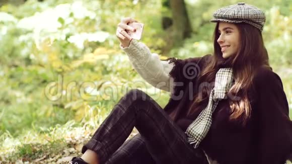 自我概念快乐的女人用智能手机浪漫的年轻女人在自然背景户外自拍视频的预览图