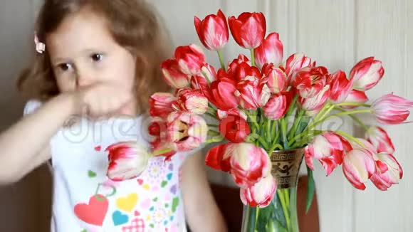 孩子嗅着郁金香花打喷嚏抓鼻子对花过敏视频的预览图