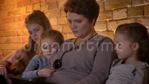 在舒适的家庭氛围中白种人的母亲和女儿在观看平板电脑时的特写家庭肖像视频的预览图