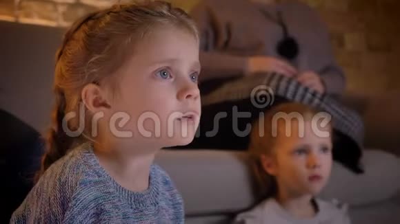 在舒适的家庭氛围中小白种人女孩看电影时的特写镜头视频的预览图