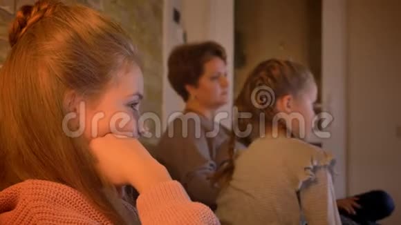 家庭肖像高加索母亲和女儿在舒适的家庭氛围中看电影视频的预览图