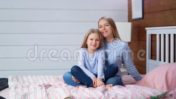 可爱的欧洲年轻女人用小可爱女孩的双手抚摸头发视频的预览图