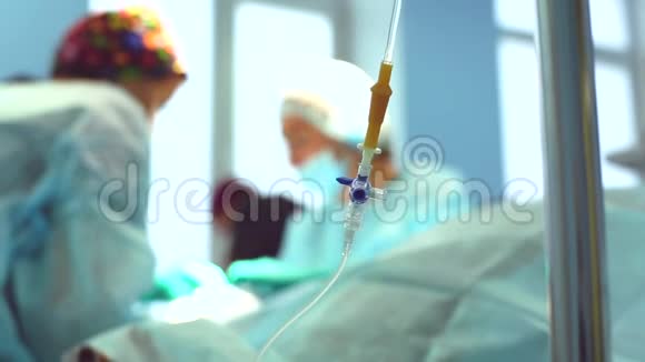 手术室模糊外科医生前景中的滴管特写视频的预览图