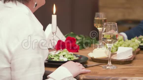 有酒和食物的成熟男性和女性手的特写视频的预览图