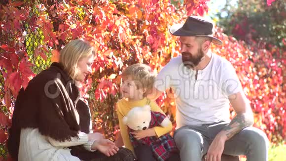 幸福的秋天家庭在爱阳光明媚的秋日快乐的年轻父母和孩子在秋天公园假日室外视频的预览图