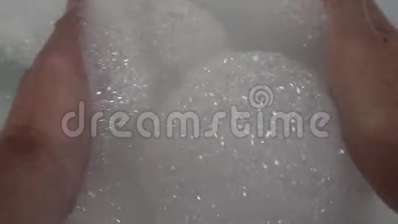 手在浴室里举起一把白色的泡沫视频的预览图