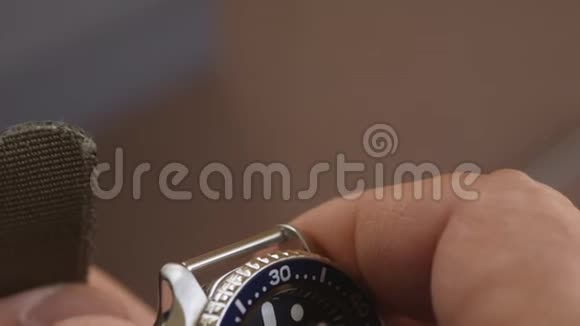 一名男子手表上戴着尼龙卡其色表带的手特写视频的预览图
