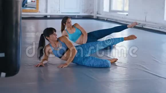 两个女运动员在健身馆锻炼腹部女运动员正在练习普拉提以增强肌肉视频的预览图