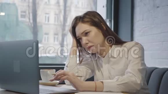 在一家舒适的咖啡馆或餐馆里坐在靠近窗户的桌子旁疲惫的少女睡着了视频的预览图