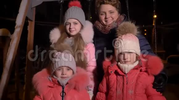 在晚上白种人的母亲和三个女儿正在吃着雪微笑地看着镜头他们的家庭画像视频的预览图