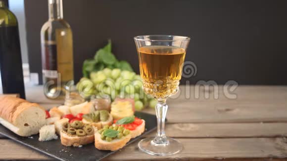 女人手拿着酒杯和白葡萄酒准备浪漫的晚餐视频的预览图