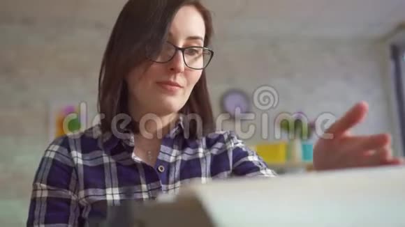 描绘一个年轻女子在一台老式打字机上积极地工作视频的预览图