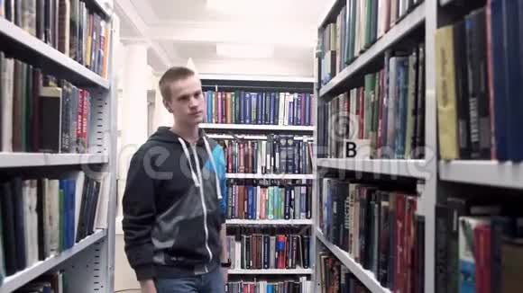 年轻的学生正在图书馆找书库存录像希普斯特学生正在图书馆找书报告视频的预览图