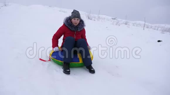 快乐的女孩很快就从雪山骑到雪碟笑了起来儿童大自然的娱乐视频的预览图