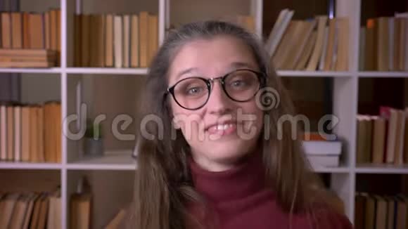 年轻的白种人女学生戴着眼镜兴奋地看着学院里的摄像机微笑的特写照片视频的预览图
