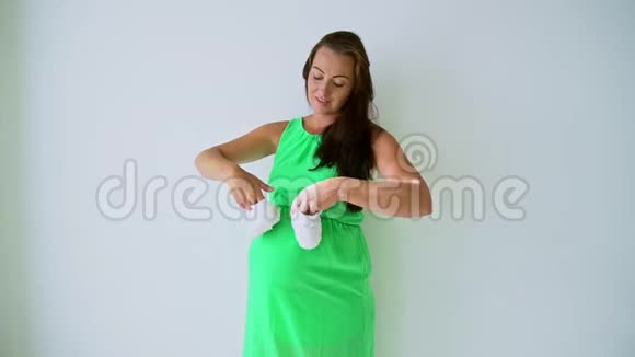 穿着内衣的怀孕妈妈在玩婴儿鞋带带的肚皮视频的预览图