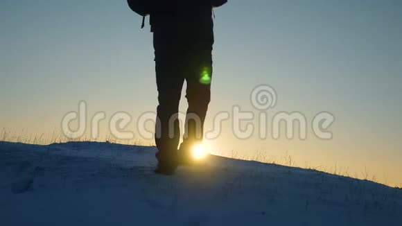 旅行者克服困难走向胜利旅行者在阳光的照耀下在一座雪山上站起来游客视频的预览图