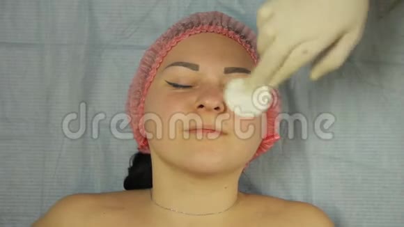 美容师的手用棉垫滋润女人脸视频的预览图