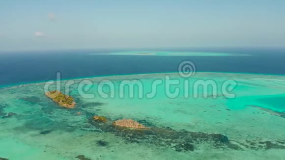 环礁和蔚蓝的大海从上面看一天一天的珊瑚礁上的小岛视频的预览图