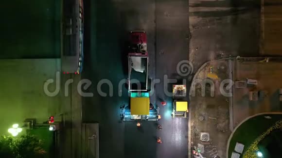 沥青铺设机夜间在城市街道工作无人机的4K录像视频的预览图
