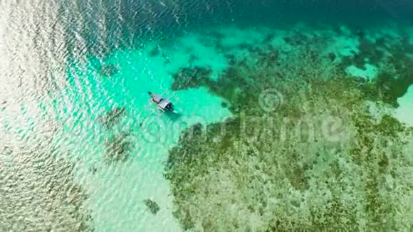 在珊瑚礁上的船海面上有一个环礁珊瑚礁海浅滩和水深视频的预览图
