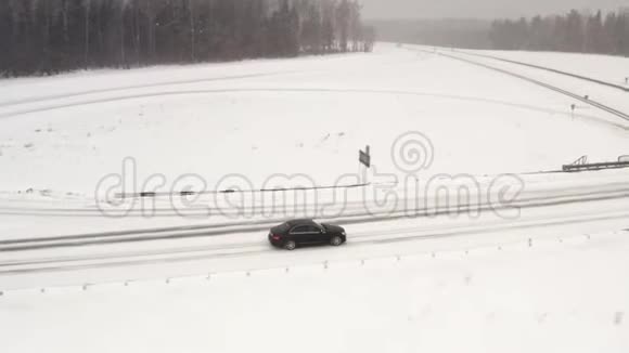 汽车搭桥汽车在冬季乡村道路上行驶从无人机在4k的空中俯瞰跟踪射击视频的预览图