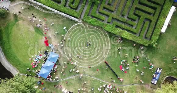 一个由草地上的石头组成的圆形迷宫很多人野餐视频的预览图
