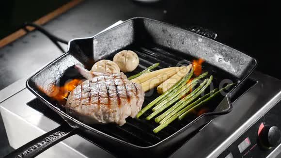 慢动作食物视频在餐厅厨房用火焰烹饪煎锅上有蔬菜的美味肉片视频的预览图