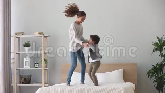 快乐的非洲男孩和白种人妈妈跳床视频的预览图