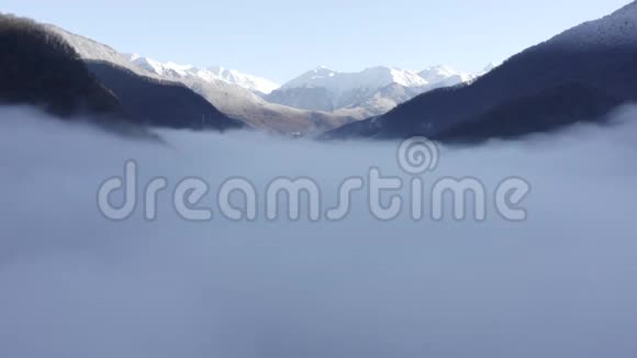 在山间山谷中无人机飞过薄雾雪峰般的雾山视频的预览图